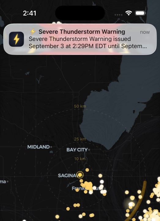 Downstrike on iPhone: a Severe Thunderstorm Warning push notification over a live lightning map of a Michigan storm